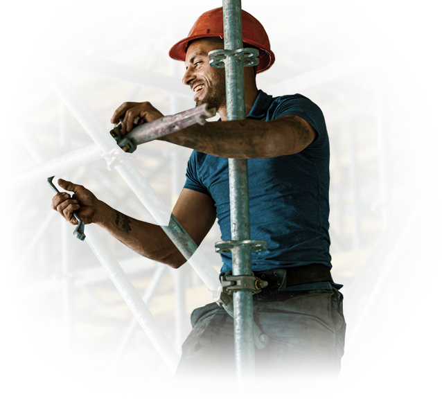 A man wearing a hard hat is working on a scaffolding