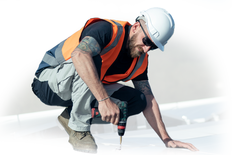 A man wearing a hard hat and safety vest is using a drill.