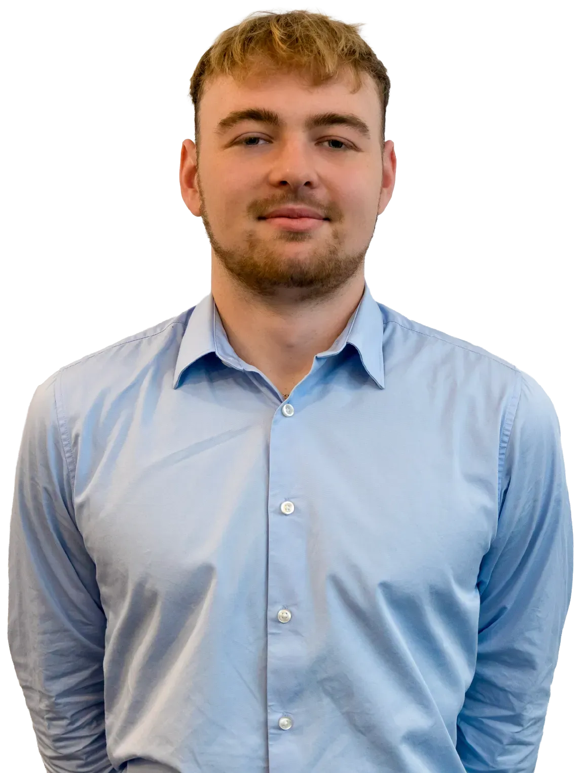 Man in light blue shirt, standing, smiling.