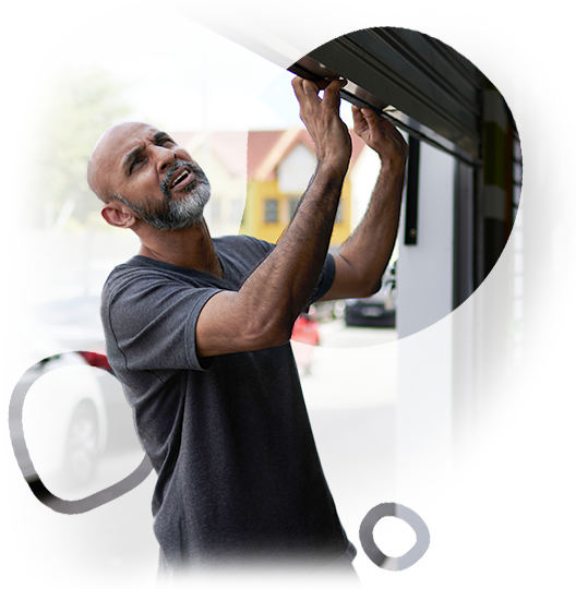 A man with a beard is working on a garage door