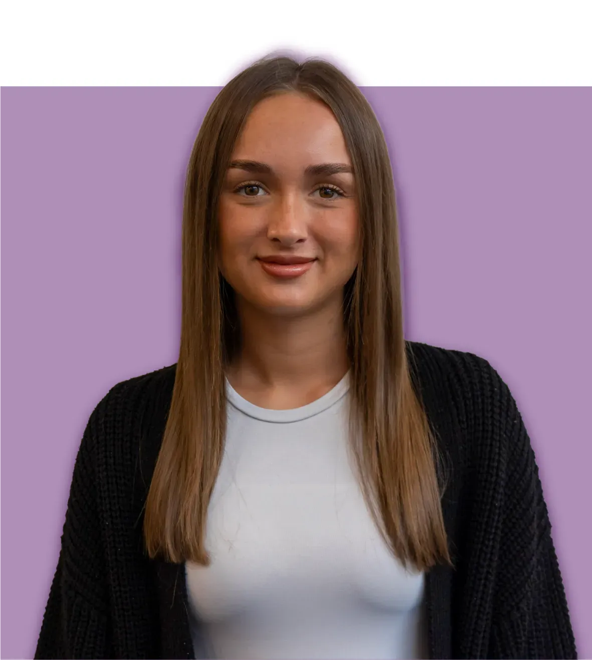 Woman with long brown hair wearing a white shirt and black cardigan smiling in front of a purple background.