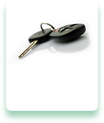 A pair of car keys are laying on a white surface.