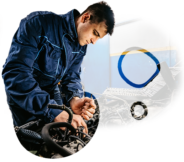 A man in a blue jacket is working on a car engine.