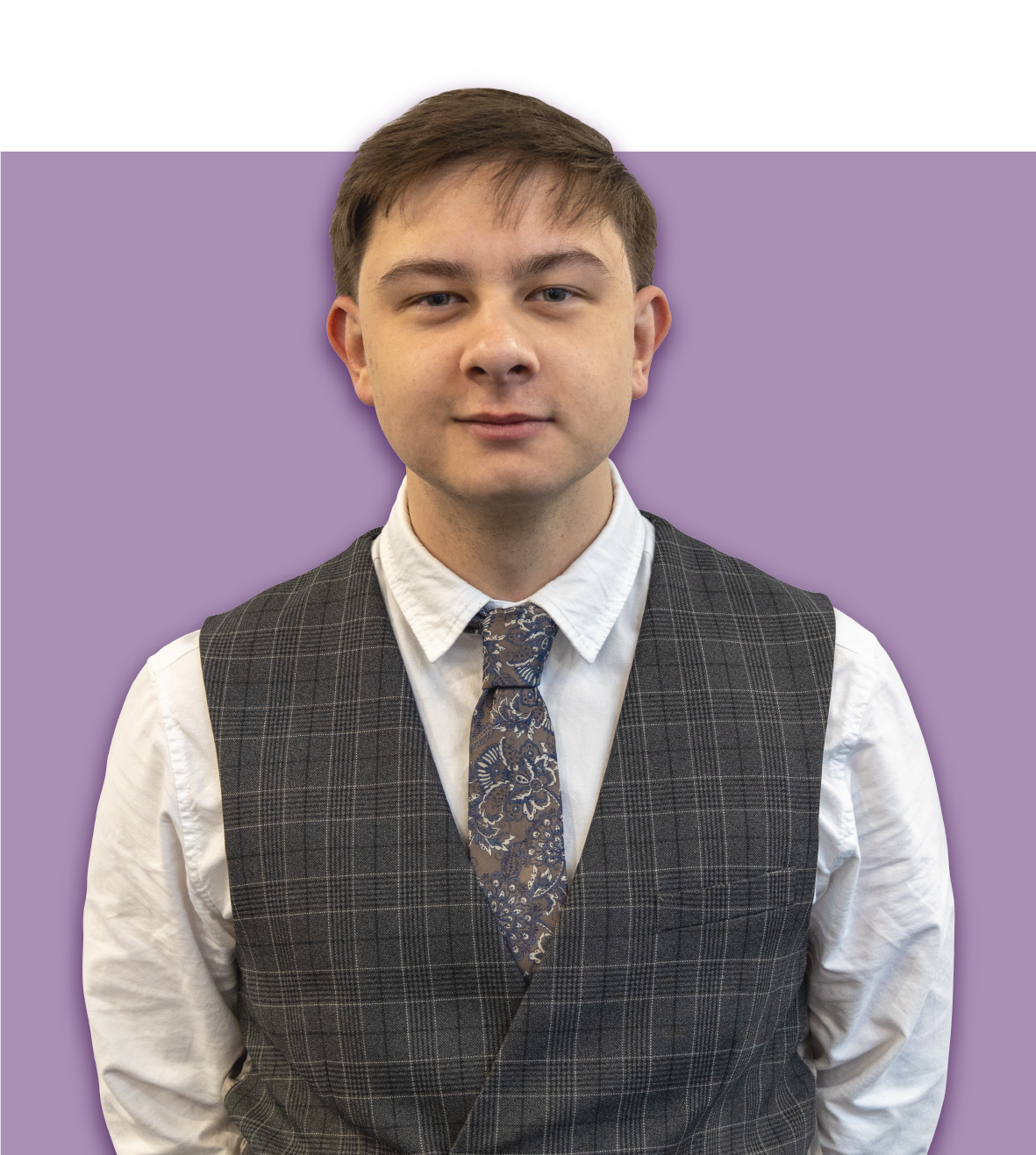 A man in a black shirt and tie stands in front of an orange background