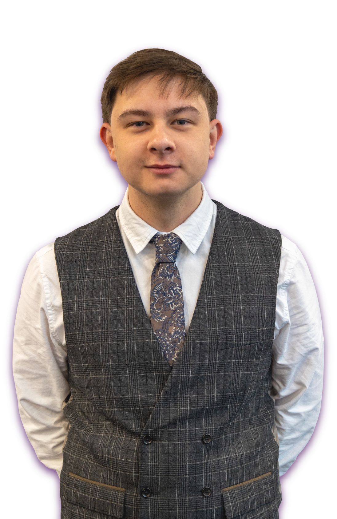 A man in a black shirt and tie stands in front of a white background