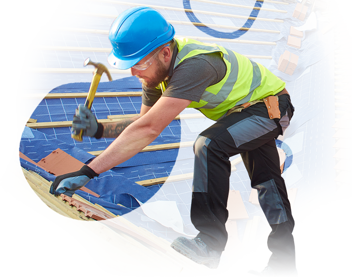 A man wearing a hard hat is working on a roof with a hammer.