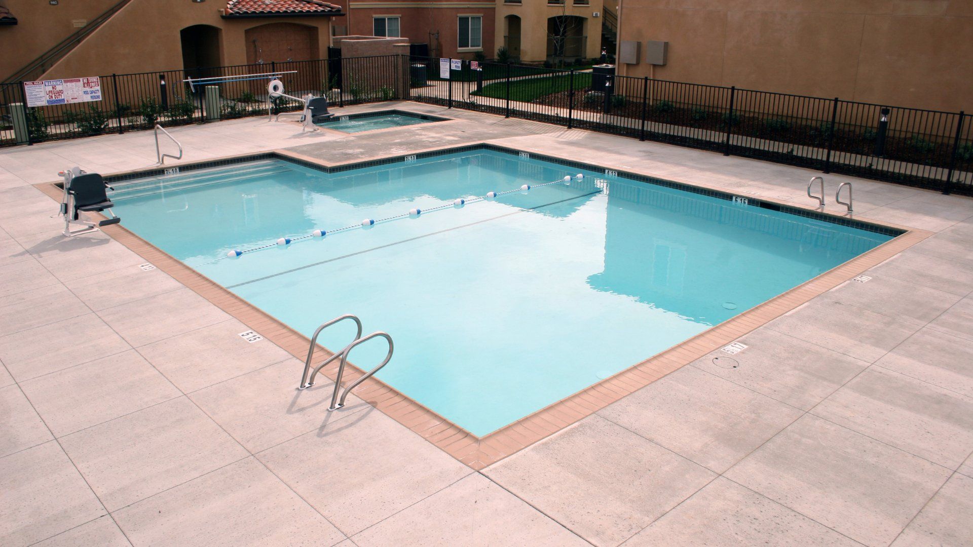 Backyard pool surrounded by a stamped concrete pool deck.