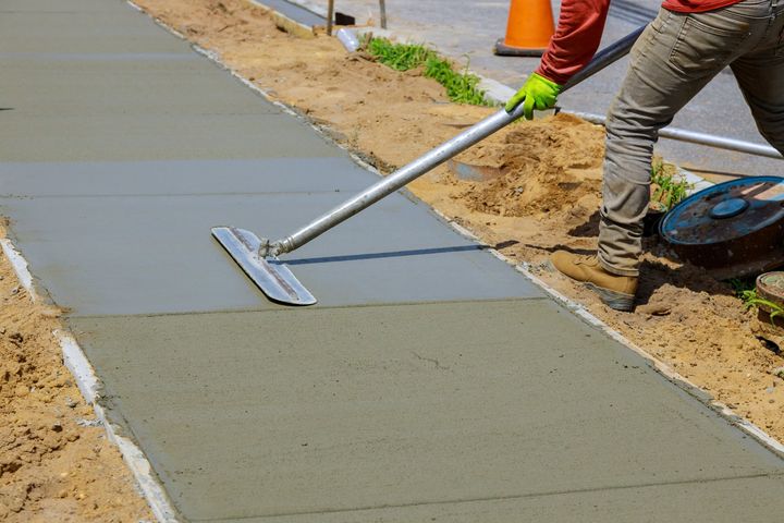 Oshawa concrete contractor smoothing out a new concrete walkway or sidewalk.