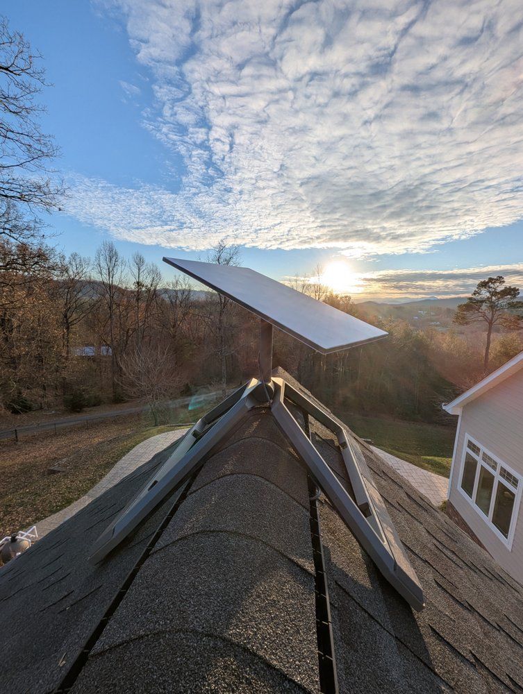 A solar panel is sitting on the roof of a house.
