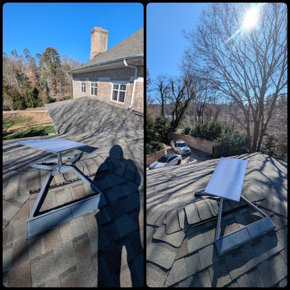 A man is standing on the roof of a house with a solar panel on it.
