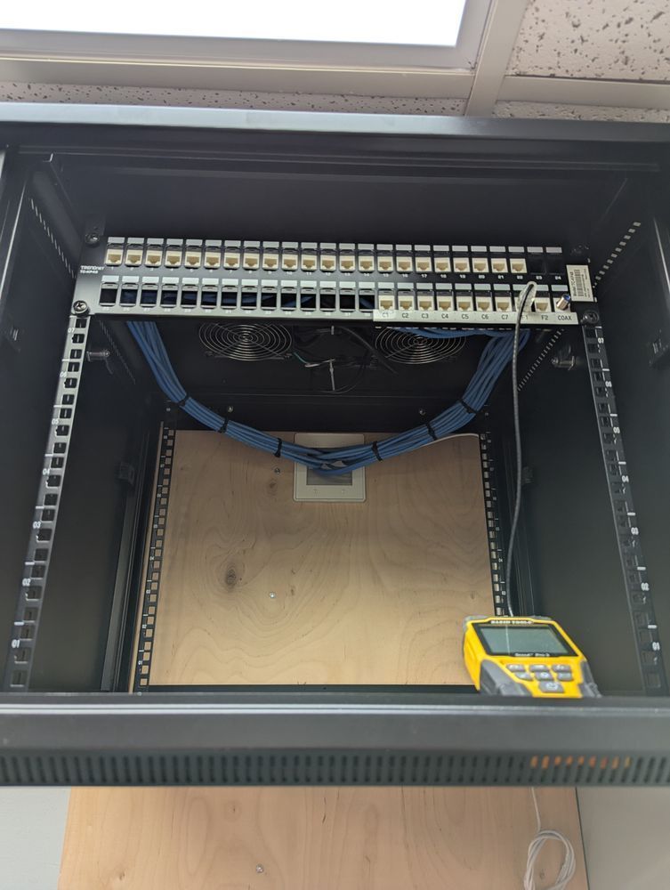 The inside of a server rack with a yellow device on top