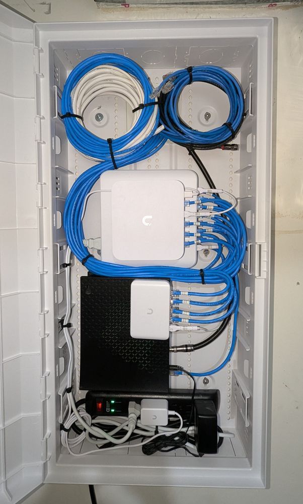 A white box filled with lots of wires and a mac computer.