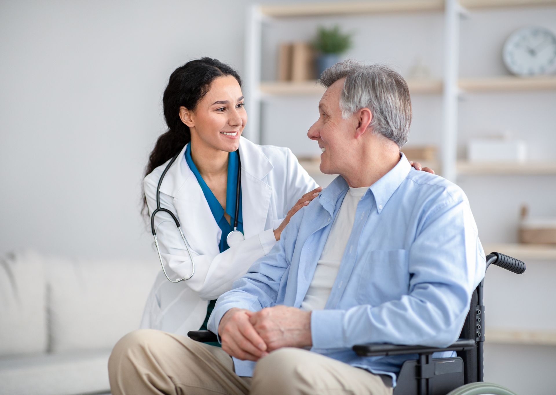 Nurse providing care to an elderly man in a wheelchair, highlighting home health care service.