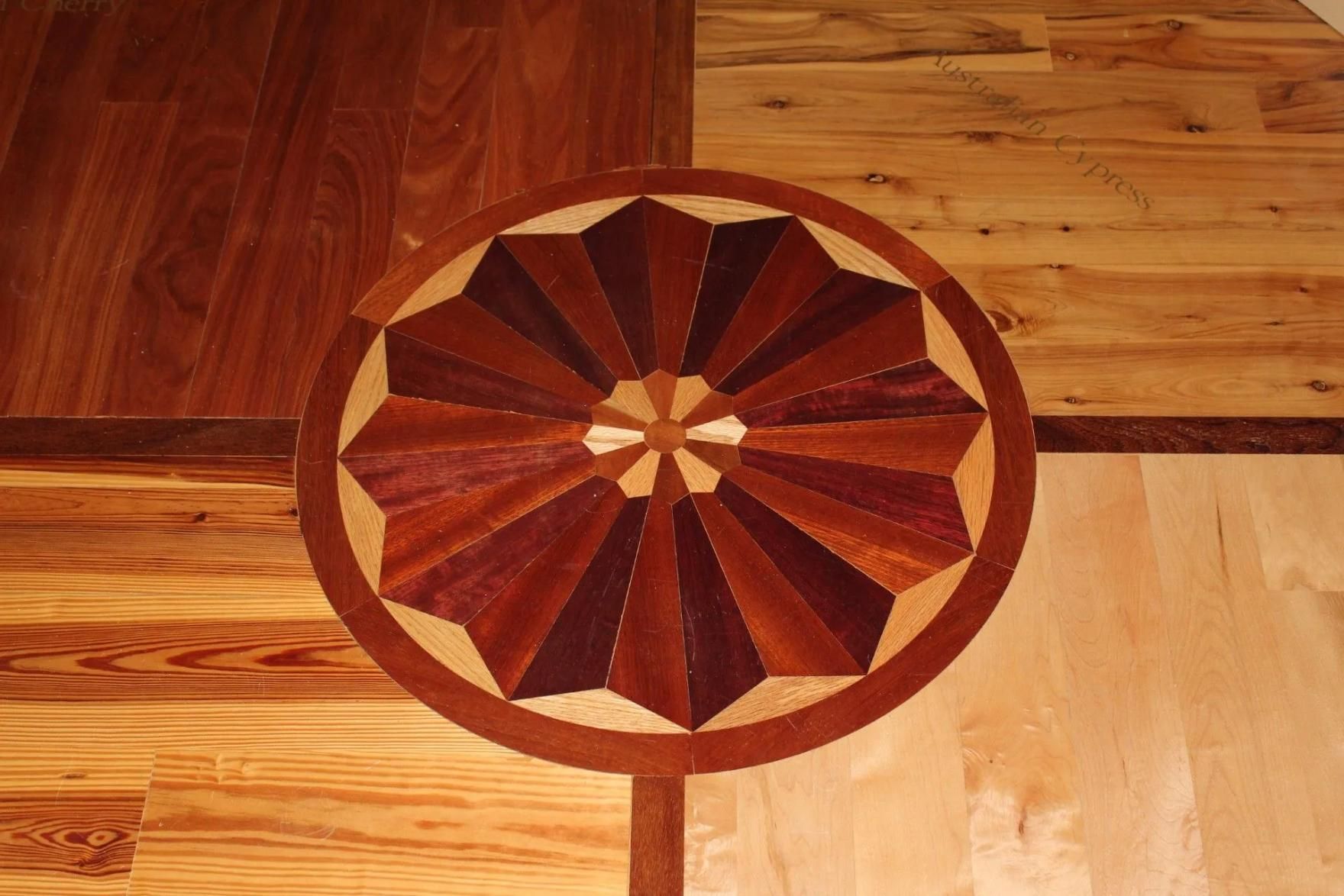 Decorative wooden floor medallion with a circular starburst pattern in warm brown tones