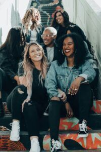 A group of women are sitting on top of a set of stairs.