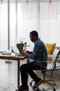 A man is sitting at a desk using a laptop computer.