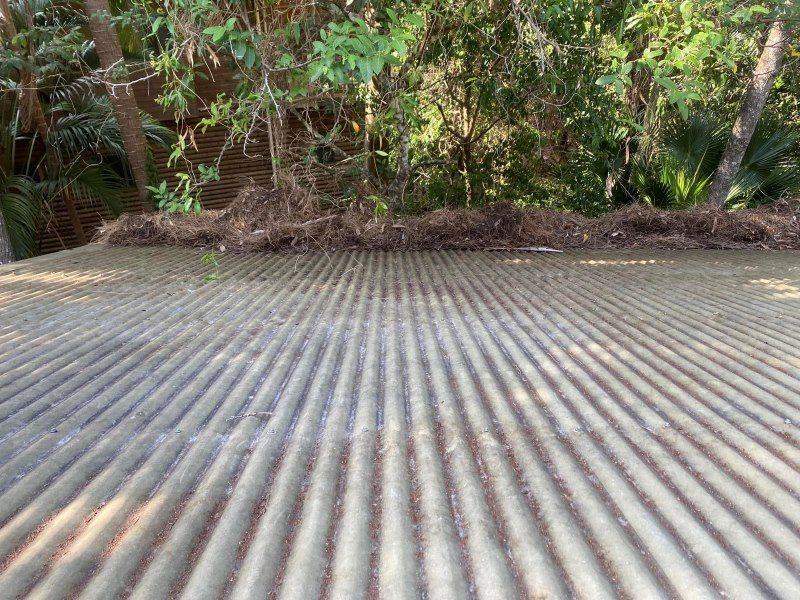 A close up of a wooden deck with trees in the background.