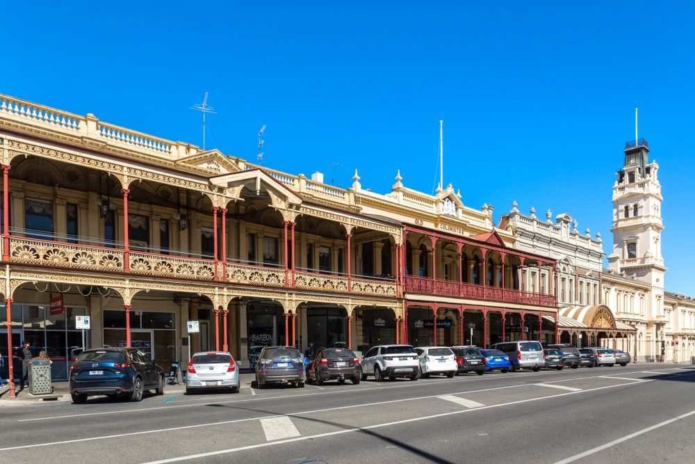A Row Of Cars Are Parked In Front Of A Large Building — The Guttering Cleaning Man in Old Bar, NSW