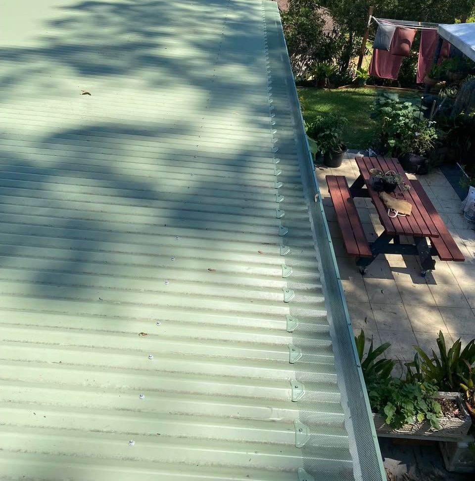A Group Of Houses With White Roofs In A Residential Area — The Guttering Cleaning Man in Pacific Palms, NSW