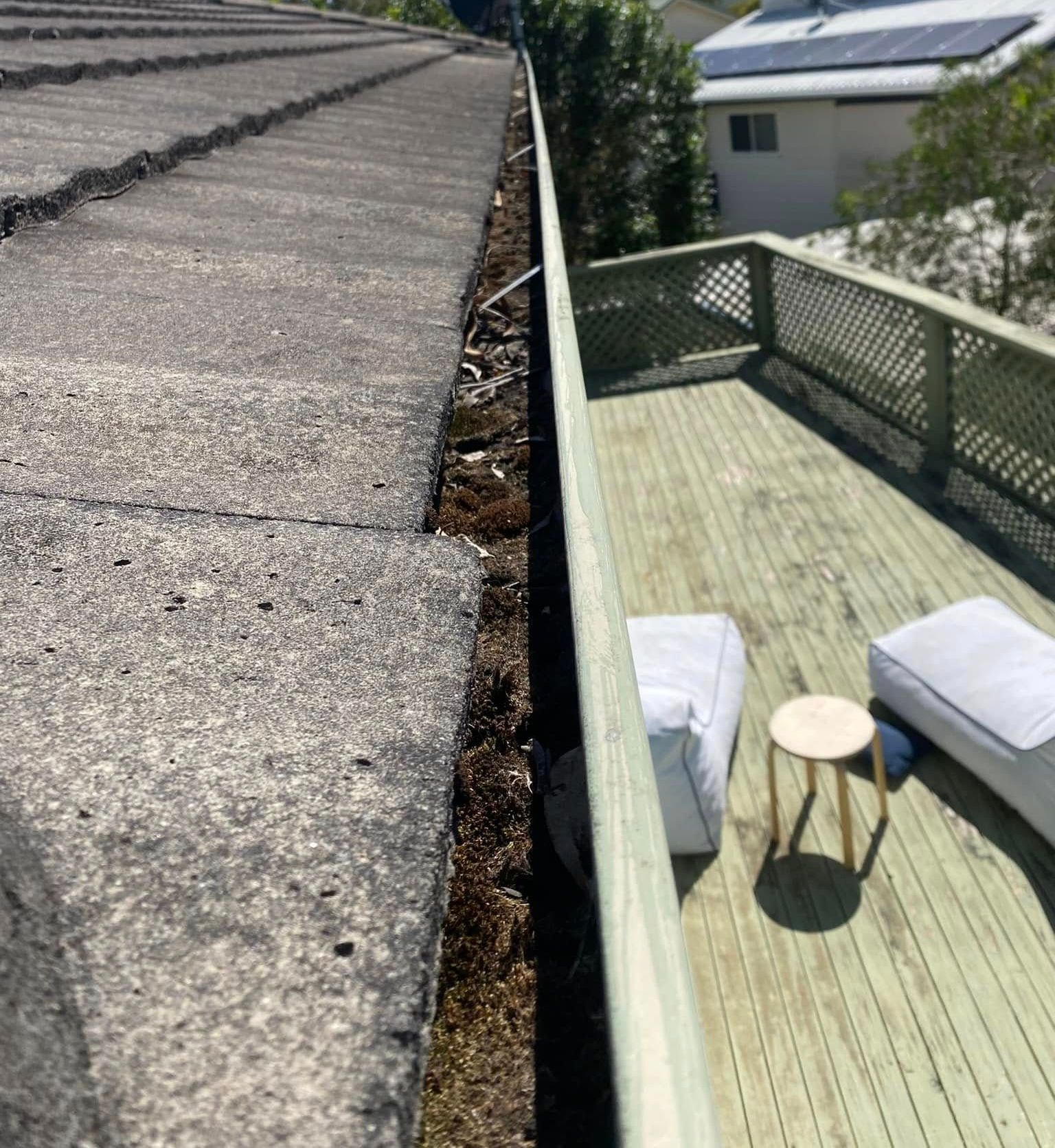 A Man Is Using A High Pressure Washer To Clean A Sidewalk — The Guttering Cleaning Man in Nabiac, NSW