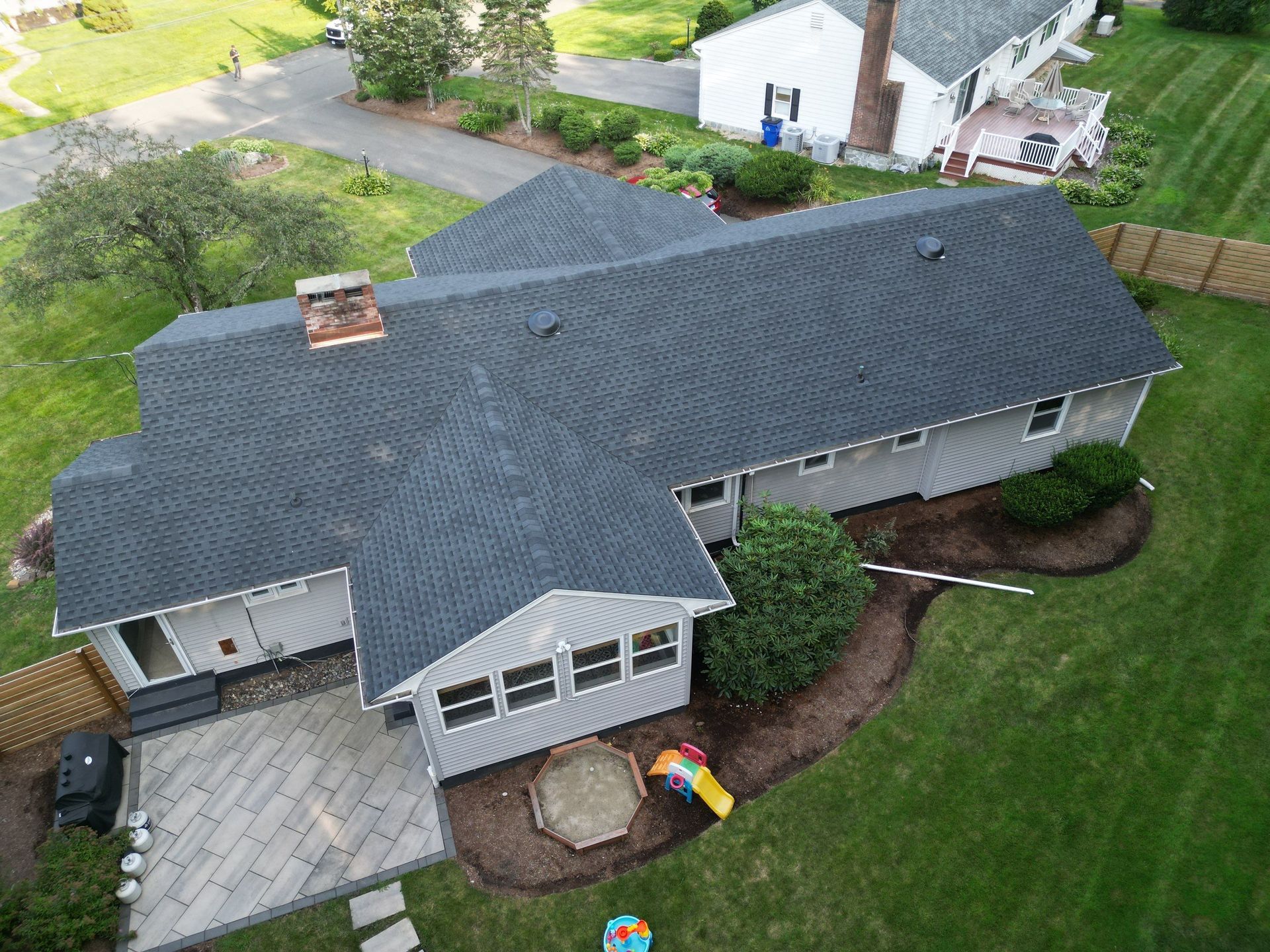 Professional roofer repairing damaged shingles on a residential home in West Hartford, Connecticut.