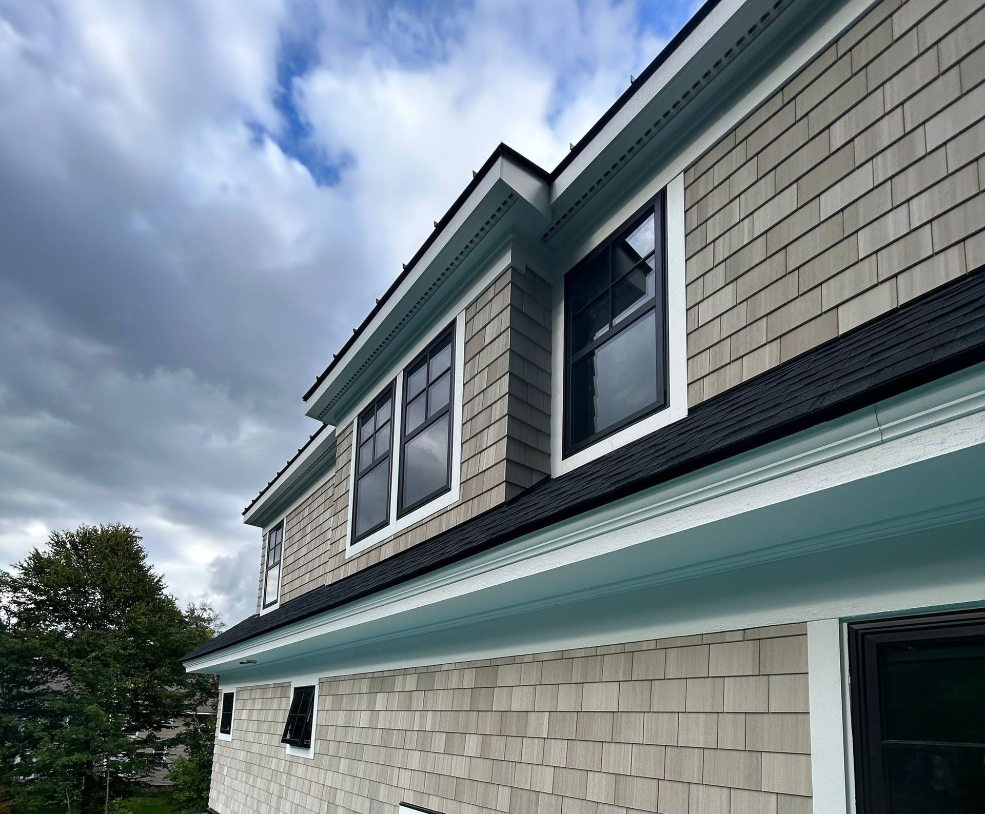 cedar siding installation by roofing professionals on a suburban home in West Hartford
