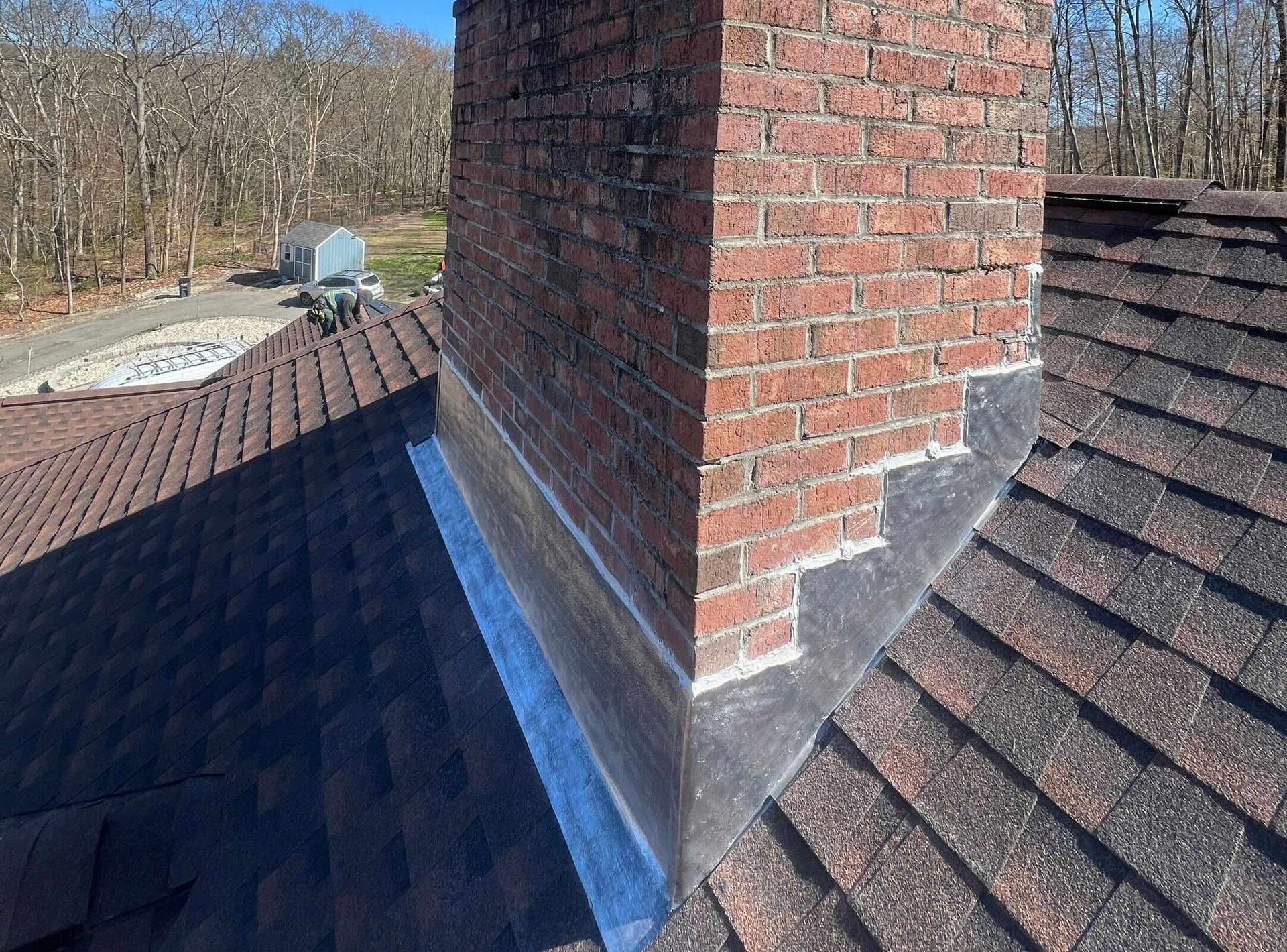 Professional roofer repairing damaged shingles on a residential home in West Hartford, Connecticut.