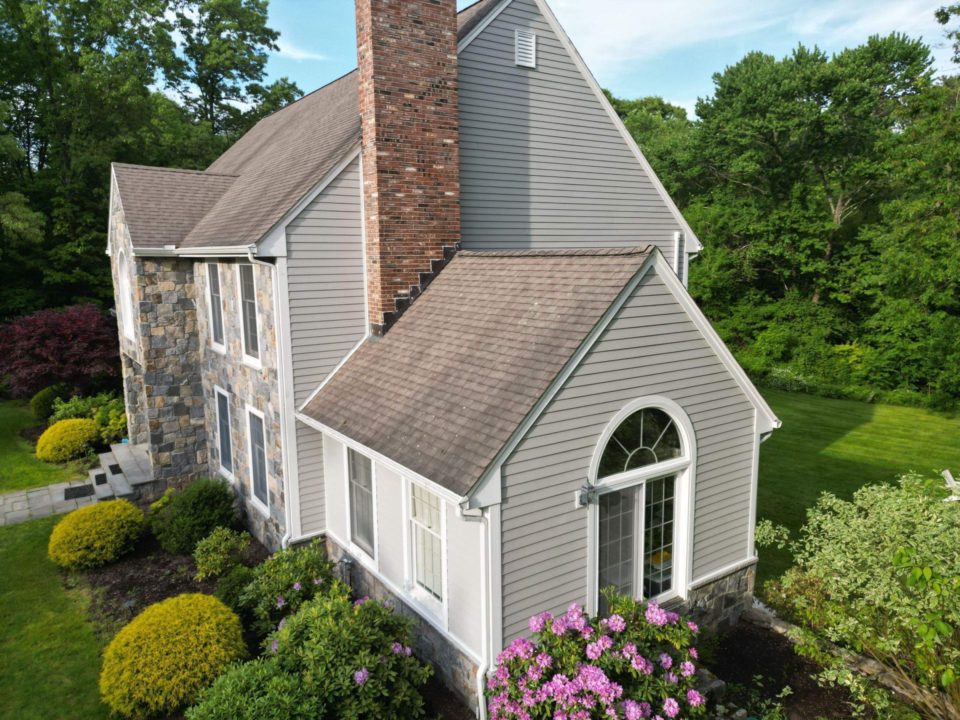 Siding installation by roofing professionals on a suburban home in West Hartford