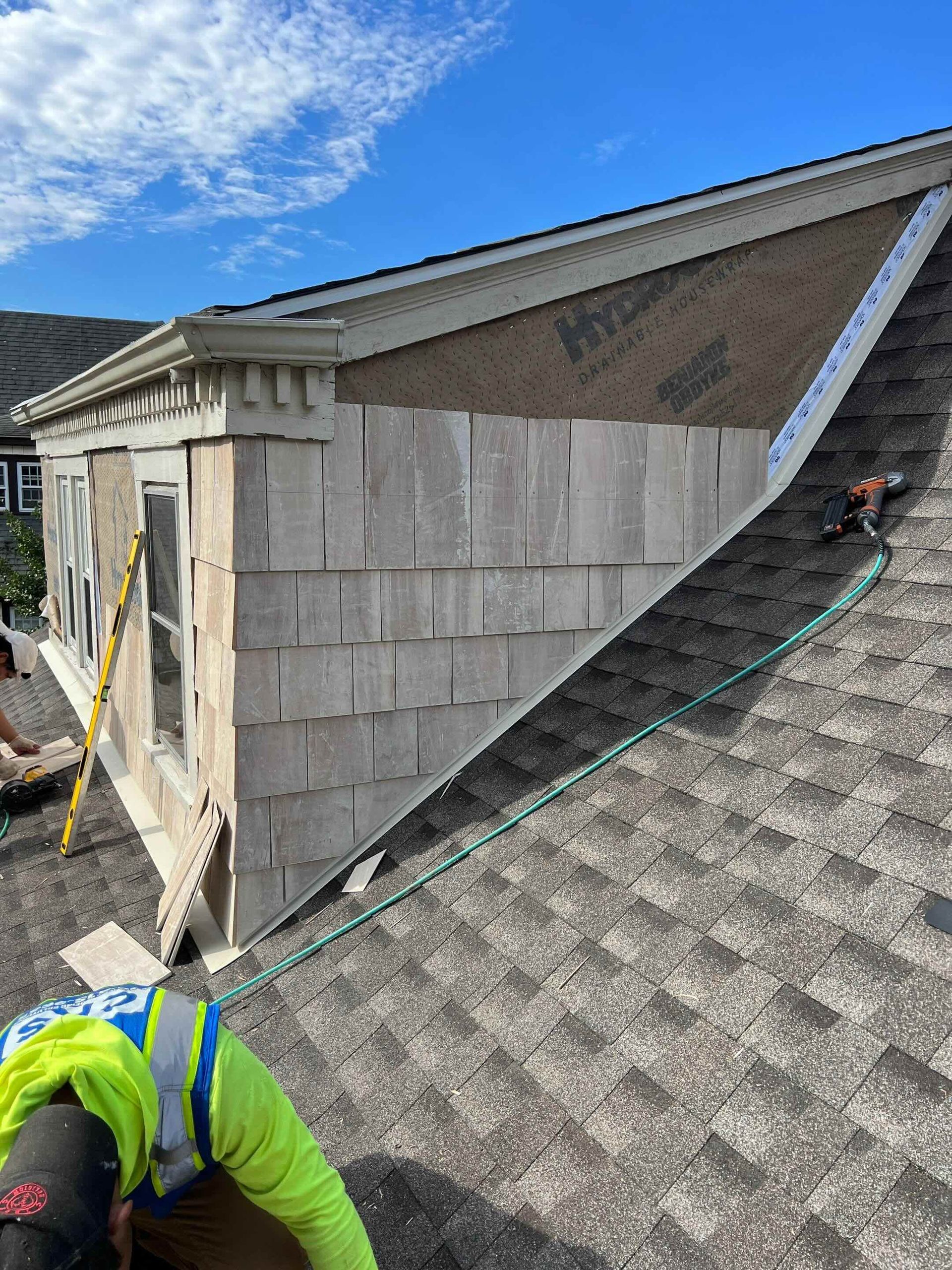 new cedar siding being installed with sidewall flashing and new roof shingles in west hartford, ct