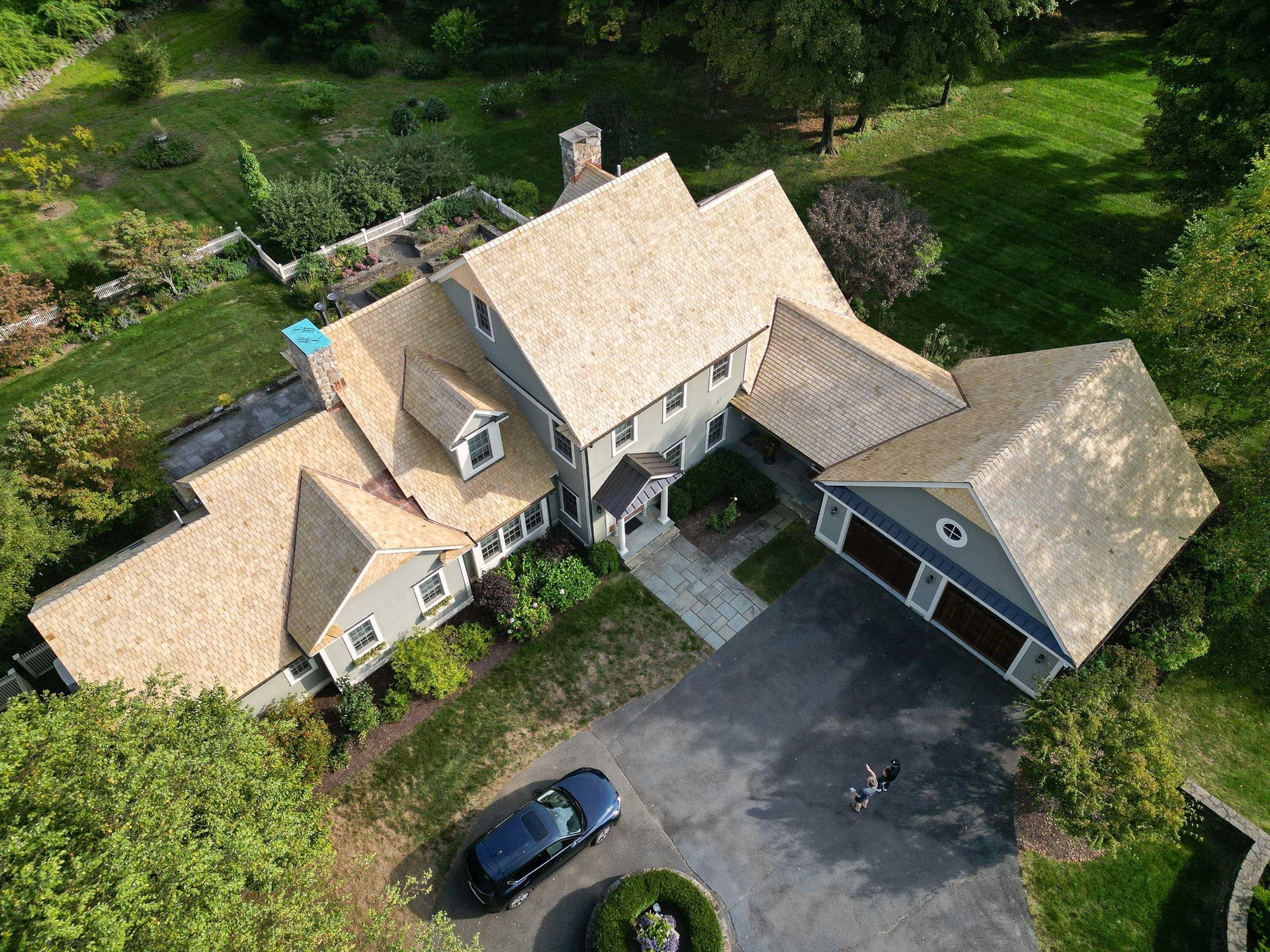 drone photo of newly installed yellow cedar roof with copper valleys installed in woodbury, ct by connecticut roofing solutions