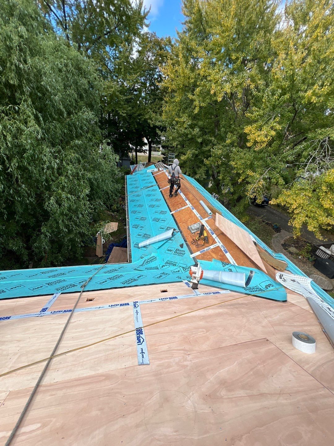 Residential Roof Installation Job Progress Picture with New Plywood and Ice and Water Underlayment on the Eves