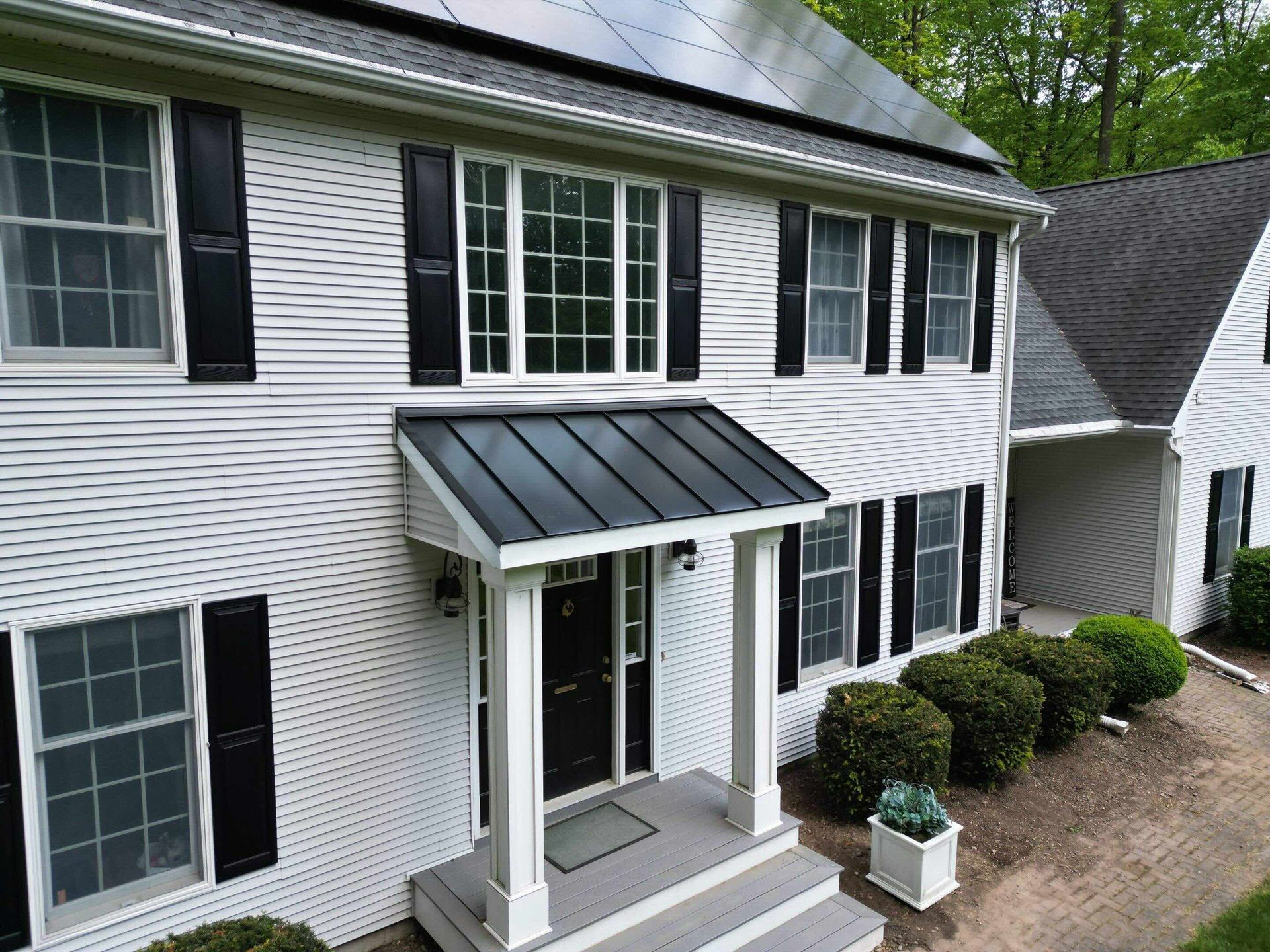 front door with standing seam metal accent in Canton, CT