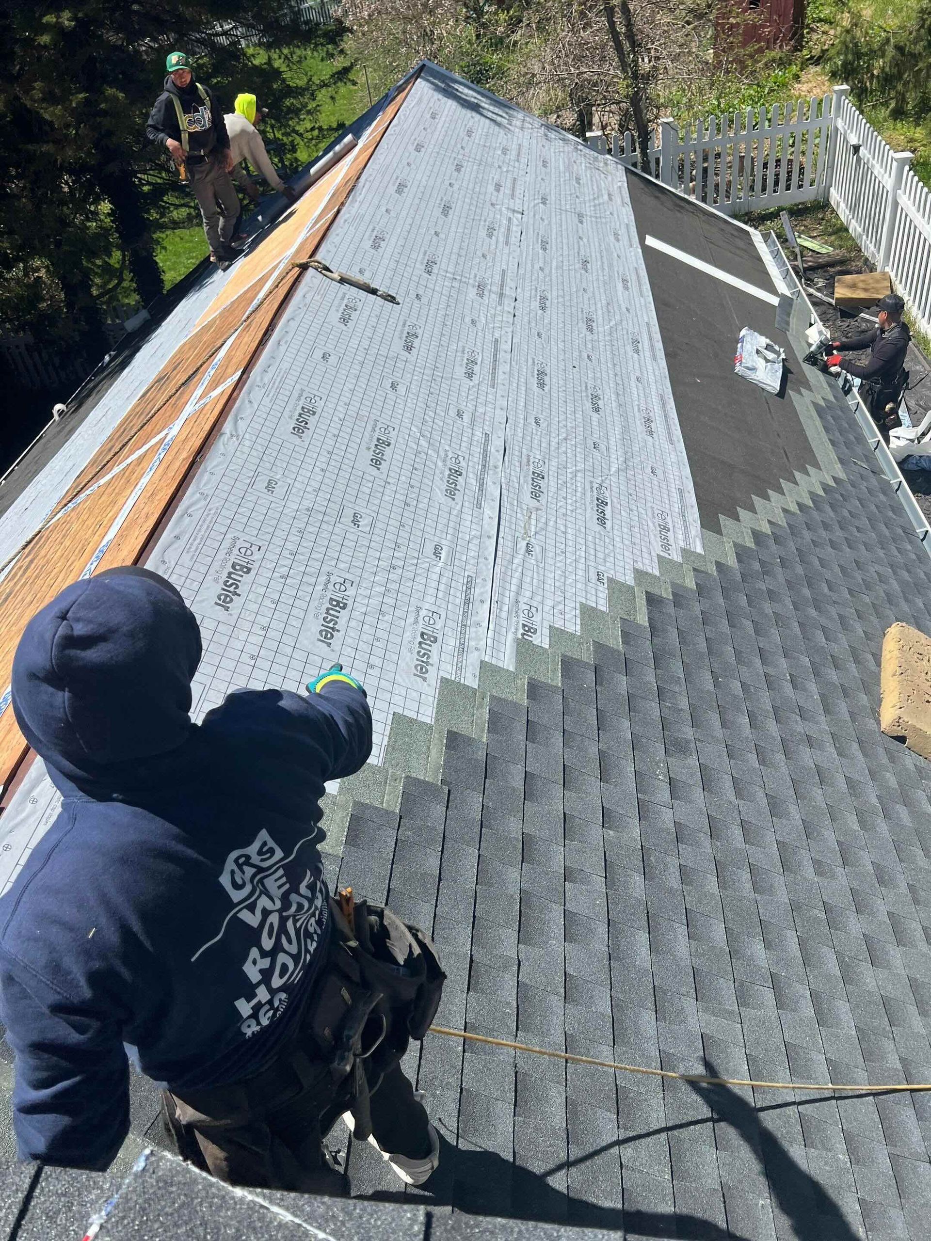 Roofing Crew installing asphalt shingles and water proof underlayment in Newtown, CT