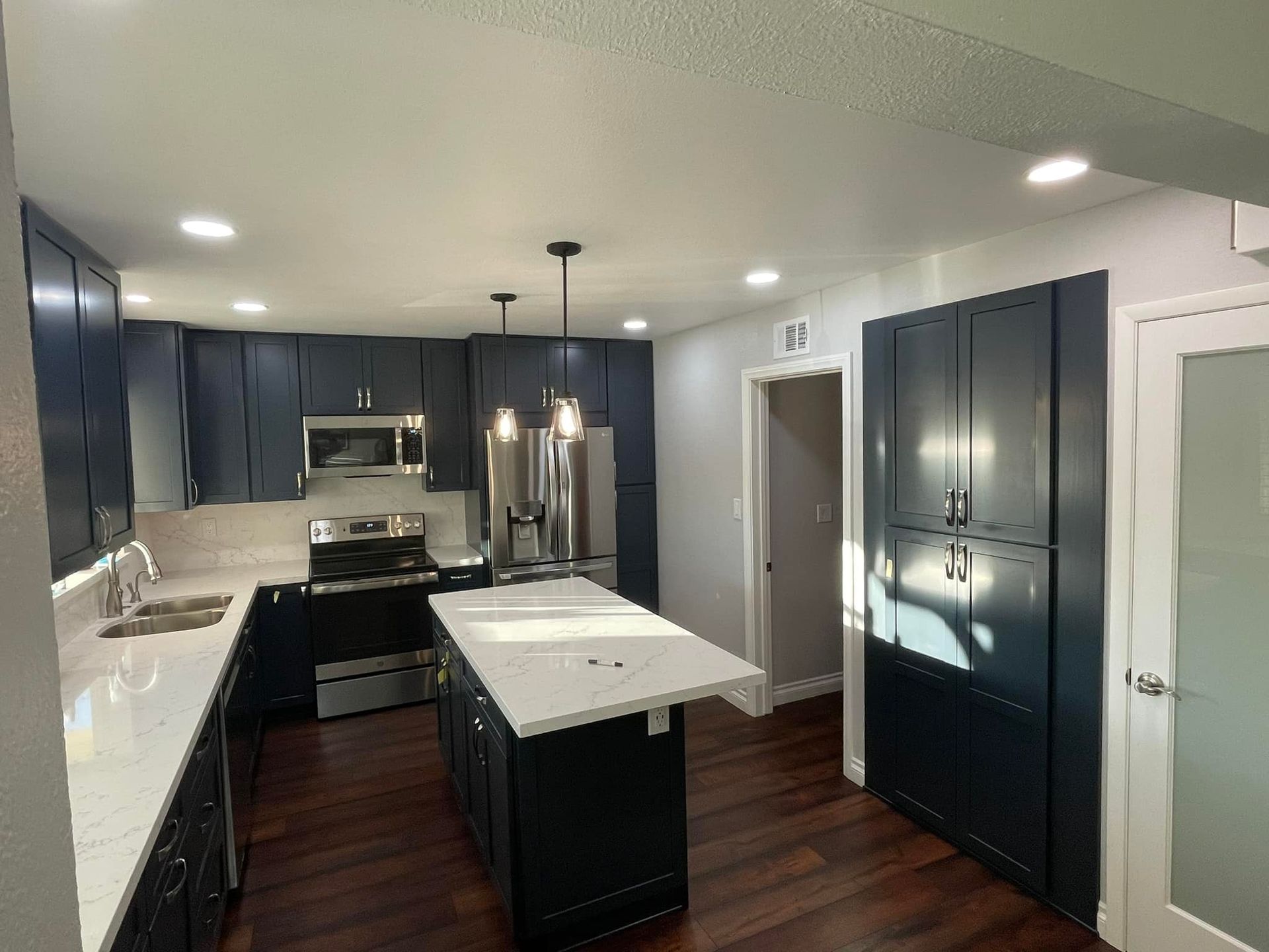 Kitchen with island, dining area, built-in shelving, high ceilings, and exposed wood beams.