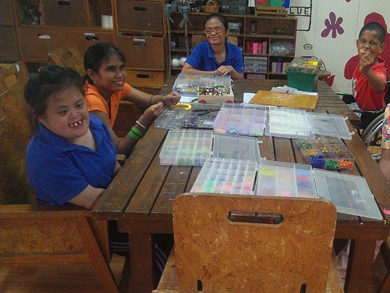 A group of children are sitting around a wooden table
