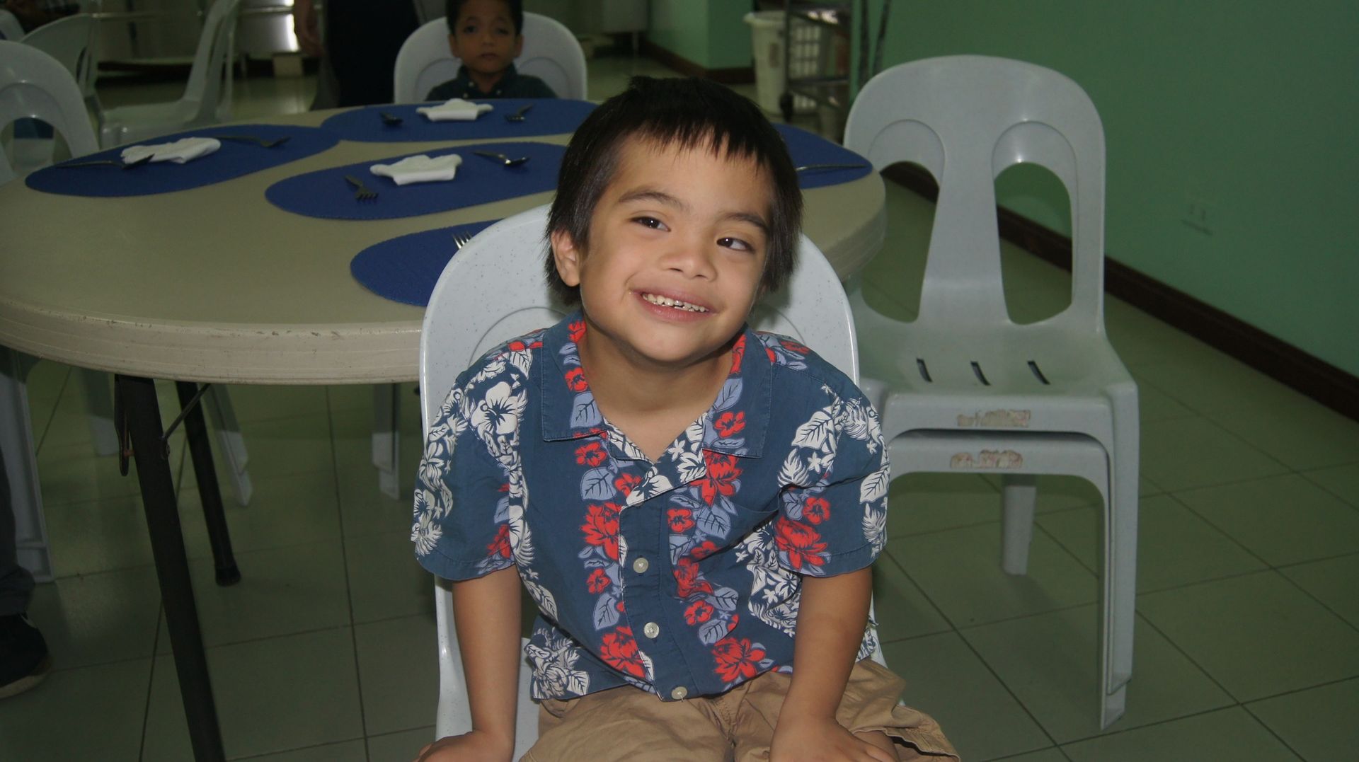 A young boy is sitting in a chair and smiling