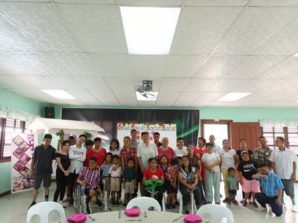 A large group of people are posing for a picture in a room.