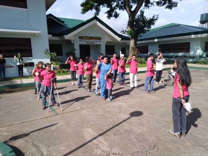 A group of people in pink shirts are standing in front of a building