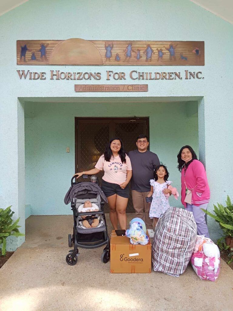 A family is posing for a picture in front of a building.