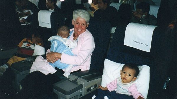 A woman is holding a baby on an airplane