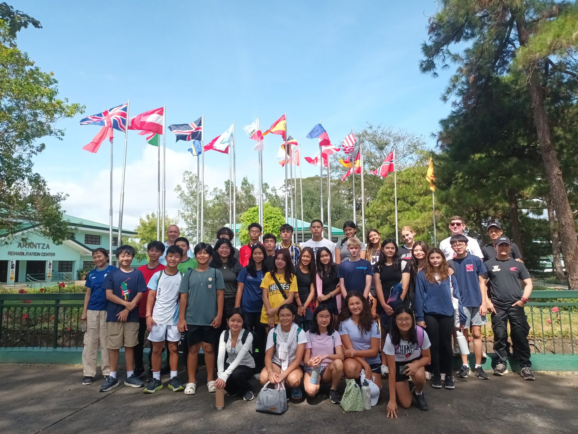 A group of people are posing for a picture in front of flags.