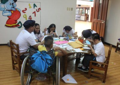 A group of children are sitting around a table with numbers on the wall behind them