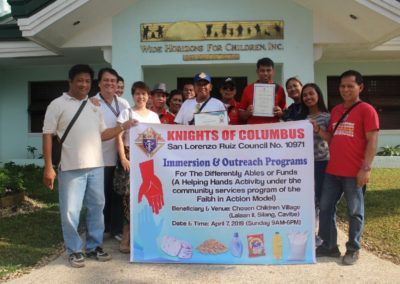 A group of people standing in front of a building holding a sign that says knights of columbus