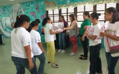 A group of girls are standing in a room with a mural on the wall.