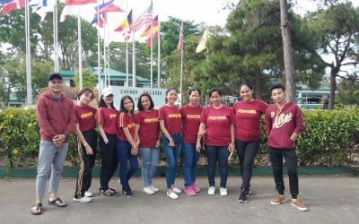 A group of people are posing for a picture in front of flags.