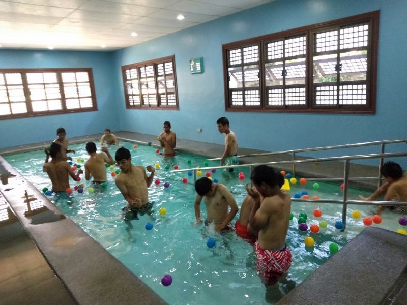 A group of people are playing in a swimming pool filled with colorful balls
