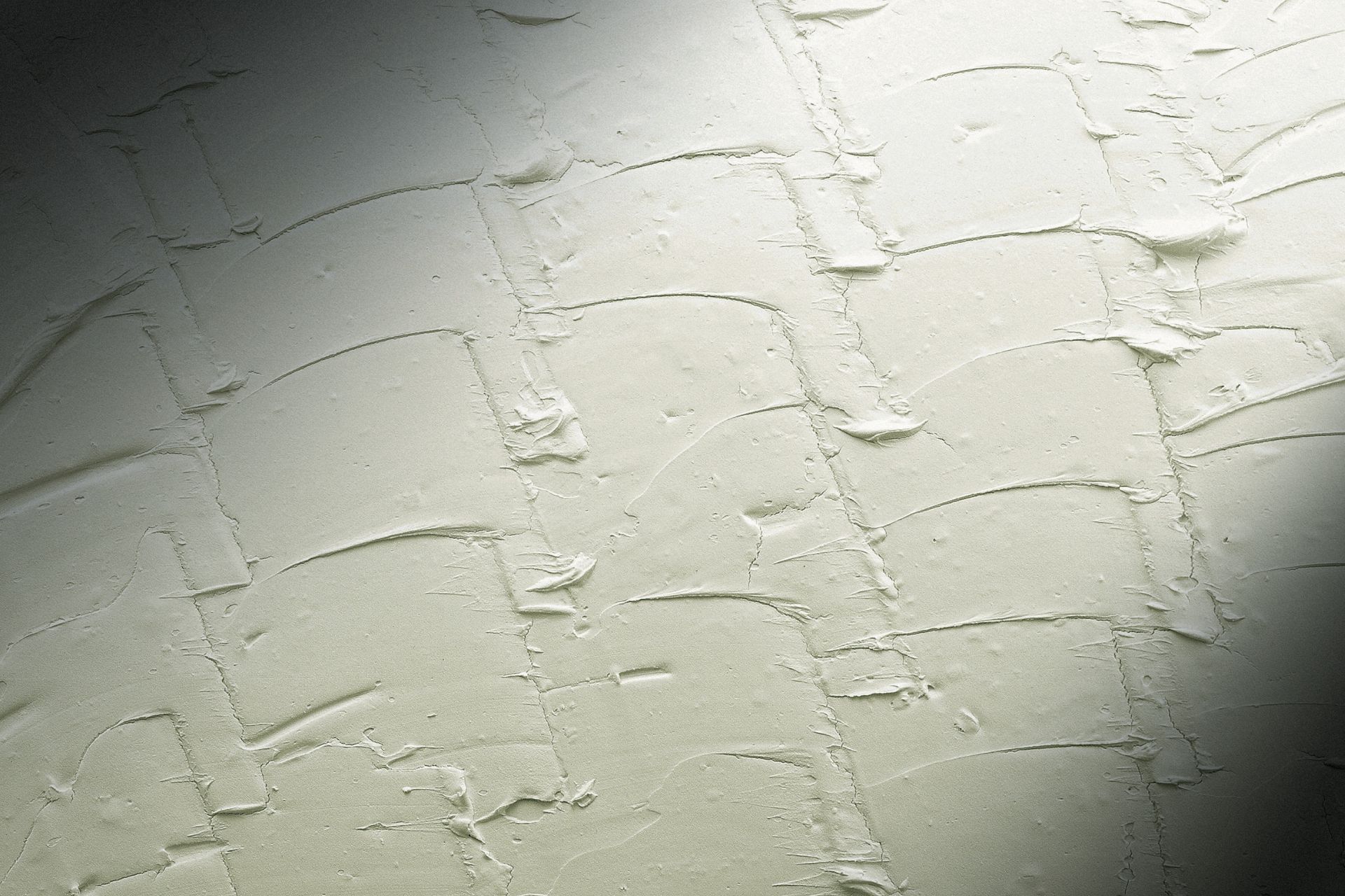 Textured white wall with curved, linear patterns and shadows.