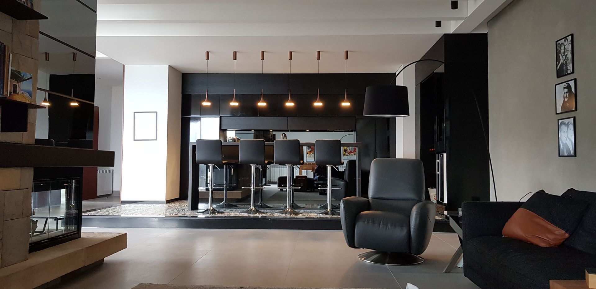 Modern living room with a bar, fireplace, and a black recliner.