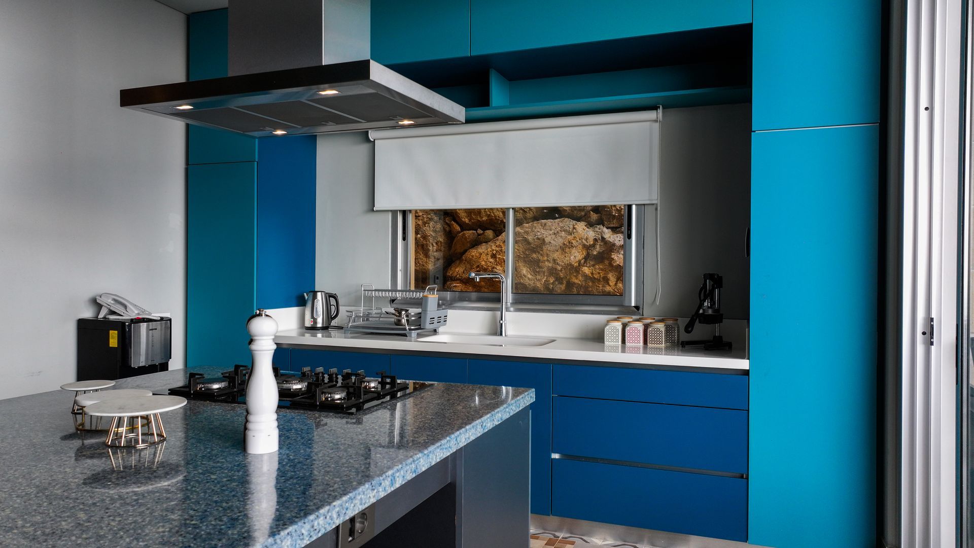 Blue and turquoise modern kitchen with island and range.