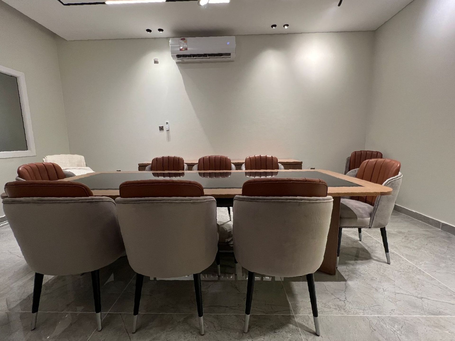 Conference room with a large wooden table and leather chairs.
